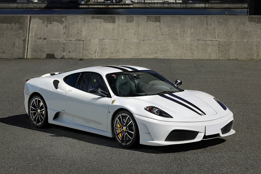 White Ferrari F430 with dark stripes, viewed from the front quarter